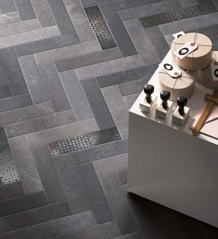 Intérieur moderne avec sol carrelage gris anthracite motif chevron, incluant carreaux décoratifs mosaïque