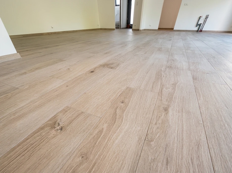 Pièce vide avec sol en carrelage imitation parquet, grands formats (environ 20x120 cm), coloris chêne naturel blanchi, pose décalée type brickwork