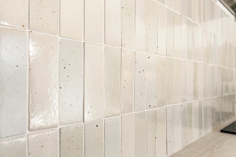 Intérieur moderne avec mur revêtu de carrelage métro blanc disposé en chevrons, éclairage encastré au plafond et lambris bois foncé en partie haute